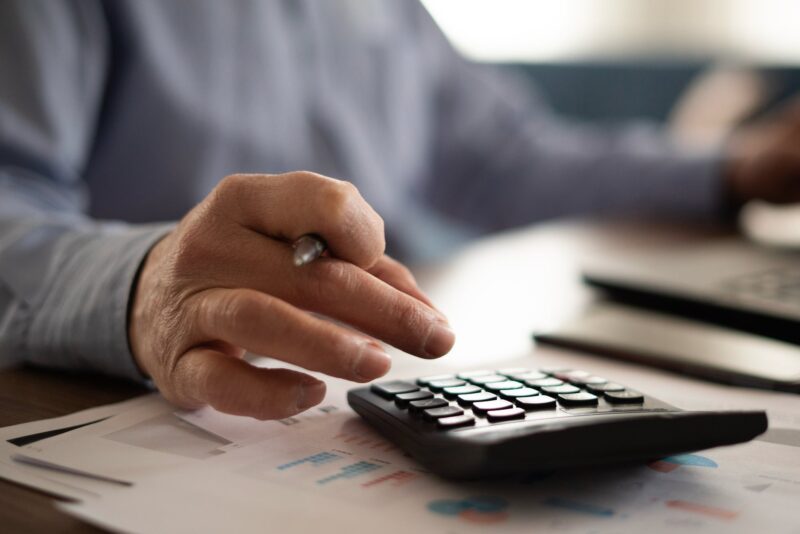 A person using a calculator to process financial documents.